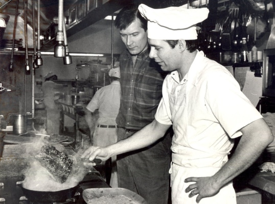 TIMES-SHAMROCK ARCHIVES In the kitchen at Cooper’s Seafood House, Mark Cooper blackens a red fish as his brother, Jack, watches on March 8, 1986.